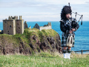 Шотландский волынщик возле замка Данноттар