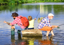 Трое мужчин ловят рыбу на реке летом