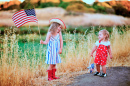 Две маленькие девочки размахивают американским флагом