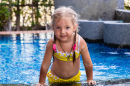 120075948-little-girl-in-a-yellow-swimsuit-in-a-blue-pool-like-a-mermaid-kids-concept-kids-fashion